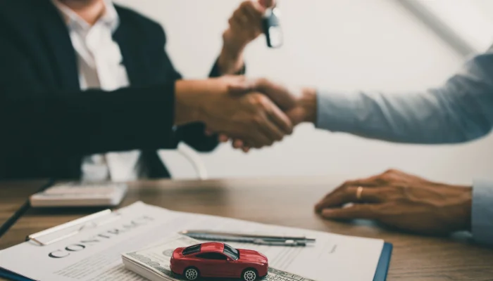 corretor fechando seguro, representando principais coberturas de um seguro de carro mensal.