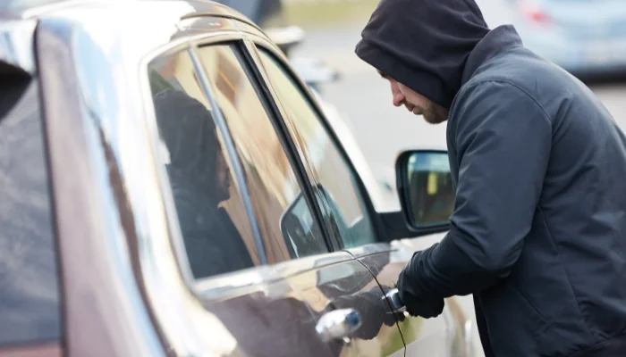 O Que Está Incluído no Seguro Roubo e Furto Carro representado por um homem tentando furtar um carro.