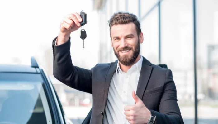 Como funciona o seguro para carro recuperado de financiamento representado por um homem com uma chave na mão.