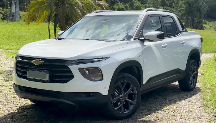 Veículo Chevrolet branco estacionado em uma estrada entre as árvores para representar a palavra-chave seguro chevrolet montana branco.