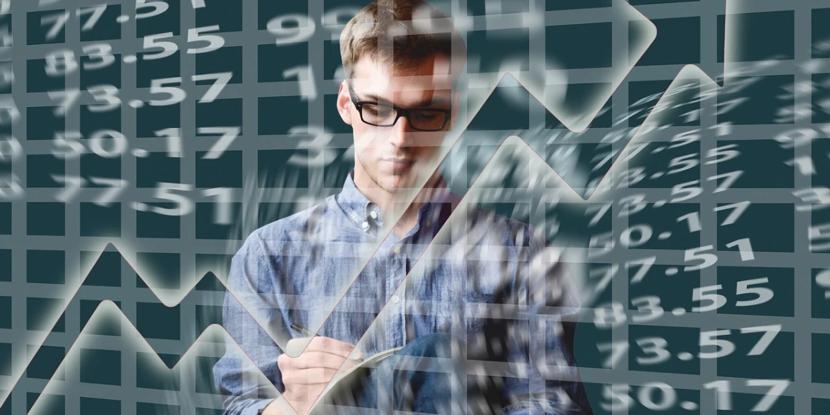 Na imagem há um homem de óculos fazendo cálculos diante de um quadro negro. Os cálculos estão soltos sobre a imagem para representar a palavra-chave seguro trailblazer.