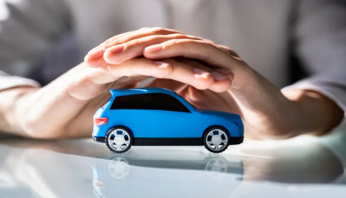 mãos protegendo carro, representando como funciona o seguro oferecido pelo banco volkswagen