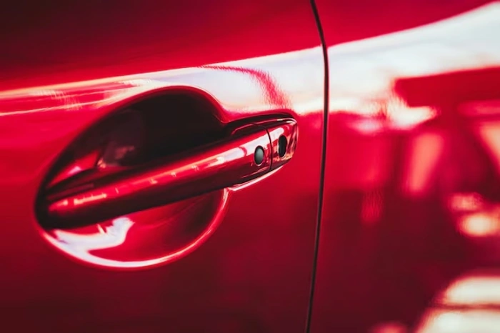 Zoom na maçaneta de carro vermelho. Explicando se a azul seguros cobre conserto de maçaneta.
