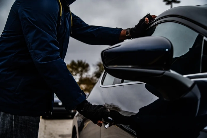 Homem abre porta de carro. Falando sobre como solicitar carro reserva azul seguros.