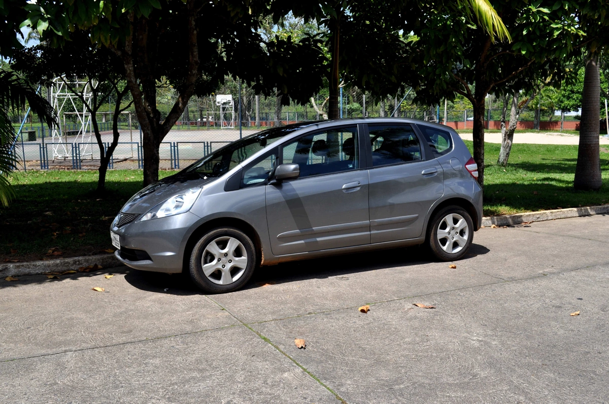 Honda Fit cinza estacionado na rua. Falando sobre seguro de carros sem garagem.