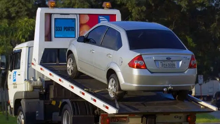 Carro em cima de guincho. Explicando se seguro auto com assistência 24h vale a pena.